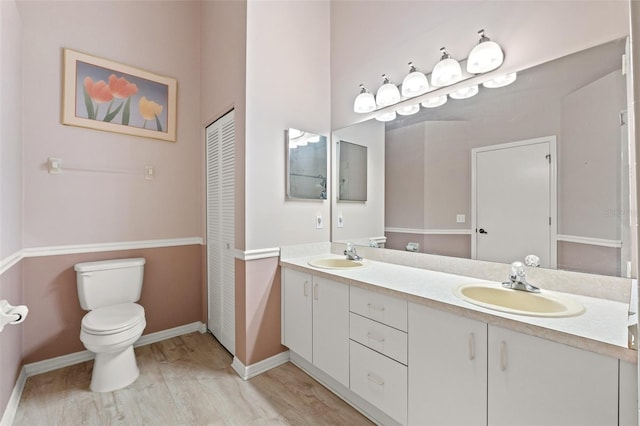 bathroom featuring toilet, wood-type flooring, and vanity