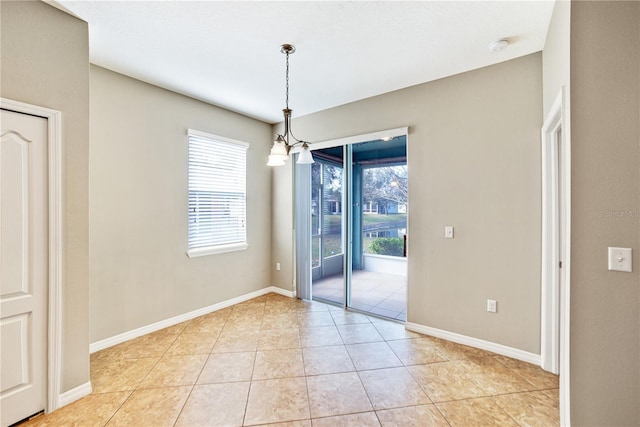 unfurnished dining area with light tile patterned floors, a chandelier, and a healthy amount of sunlight