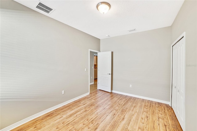 unfurnished bedroom with light hardwood / wood-style floors and a closet