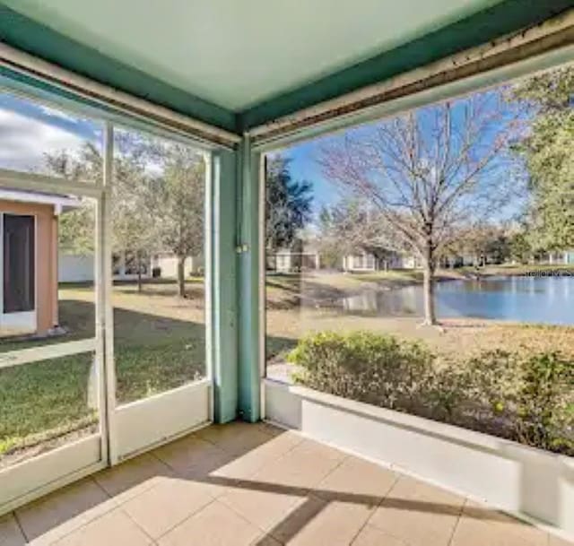 unfurnished sunroom featuring a water view