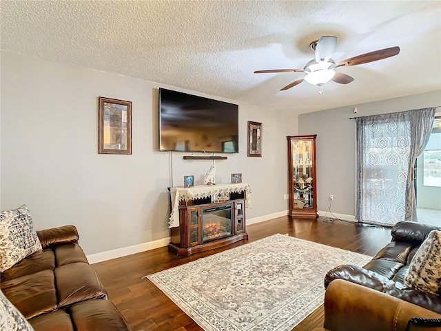 living room featuring a textured ceiling, ceiling fan, and dark hardwood / wood-style flooring