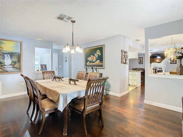 dining area with dark wood-type flooring and a notable chandelier