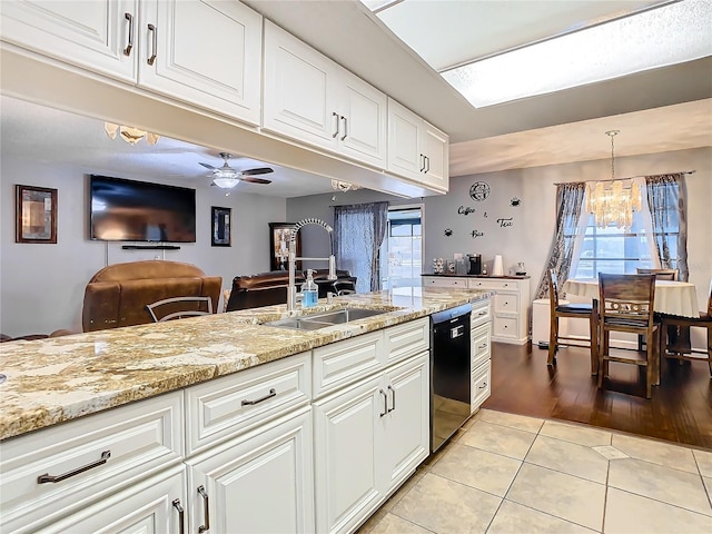 kitchen with ceiling fan with notable chandelier, white cabinets, black dishwasher, hanging light fixtures, and light tile patterned floors