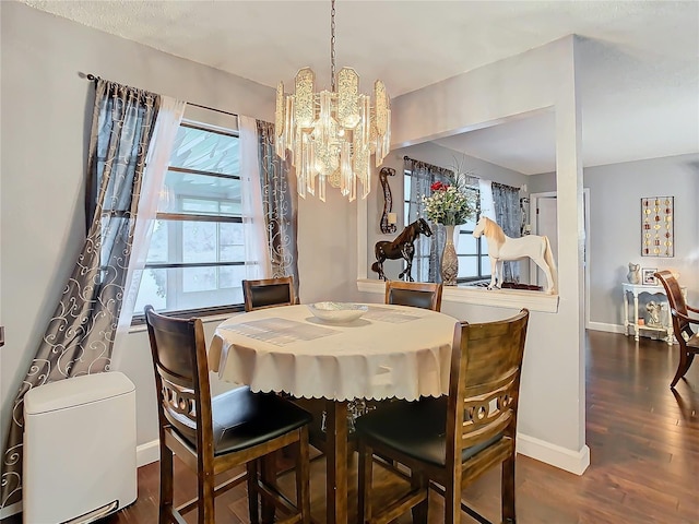 dining space with dark hardwood / wood-style floors and a notable chandelier