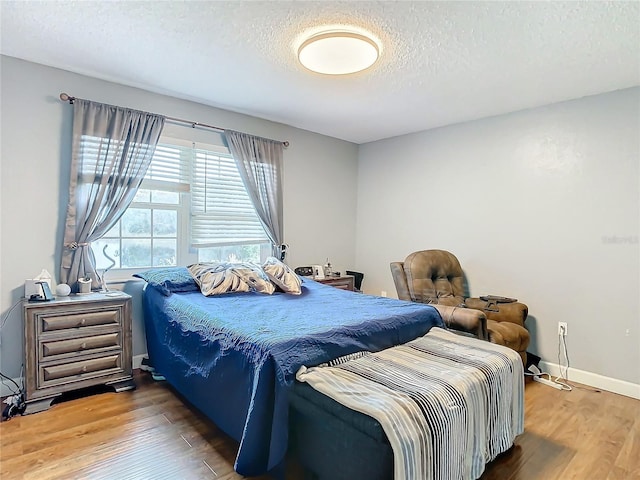 bedroom with wood-type flooring and a textured ceiling