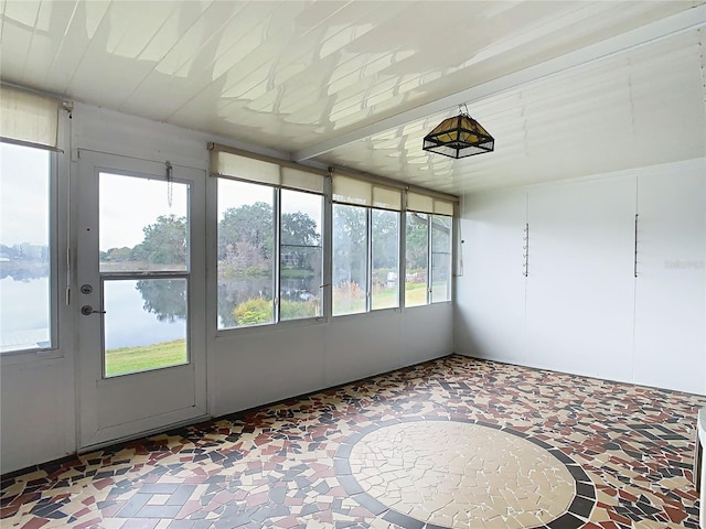 unfurnished sunroom featuring a water view