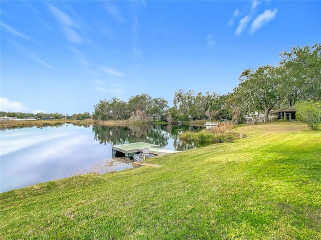 view of dock featuring a water view and a yard