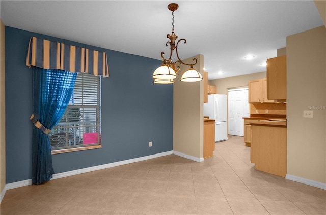 unfurnished dining area featuring light tile patterned floors and a chandelier