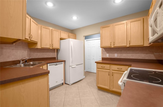 kitchen featuring tasteful backsplash, light brown cabinets, sink, and white appliances