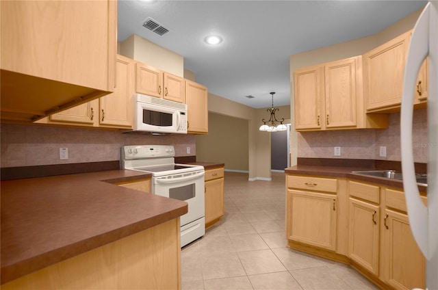 kitchen featuring white appliances, an inviting chandelier, light brown cabinetry, hanging light fixtures, and light tile patterned floors