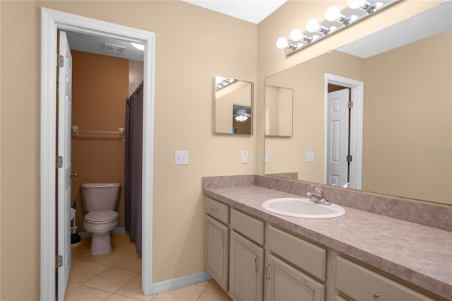 bathroom with toilet, vanity, and tile patterned flooring