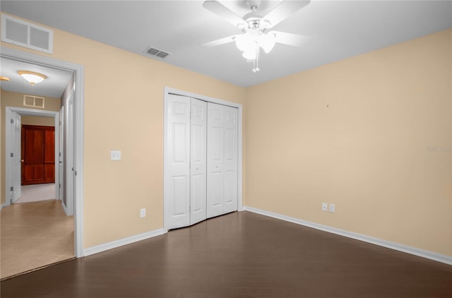 unfurnished bedroom featuring ceiling fan, a closet, and dark hardwood / wood-style flooring