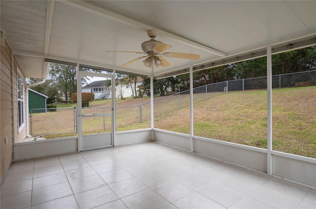 unfurnished sunroom featuring ceiling fan and plenty of natural light