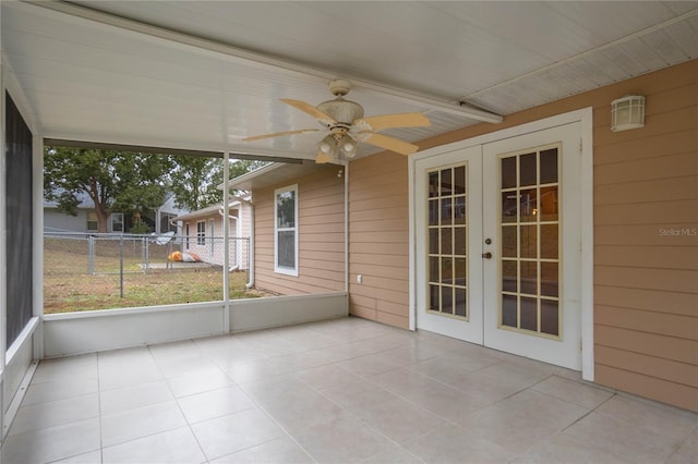 unfurnished sunroom featuring ceiling fan and french doors