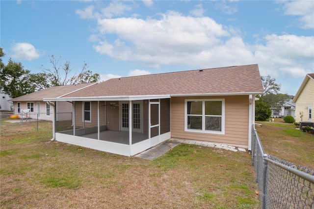 rear view of property featuring a yard and a sunroom