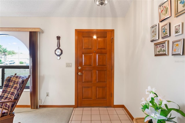 entryway featuring a textured ceiling and light tile patterned floors