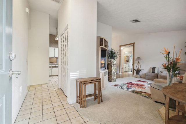 corridor featuring light tile patterned floors and vaulted ceiling