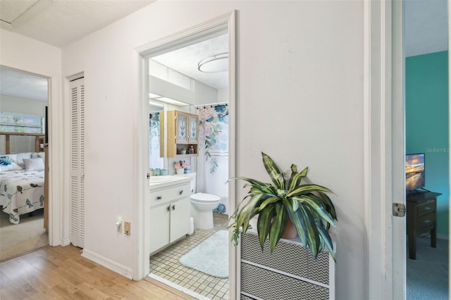 bathroom with toilet, vanity, a textured ceiling, and hardwood / wood-style floors