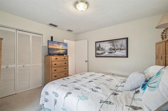 carpeted bedroom featuring a textured ceiling and a closet