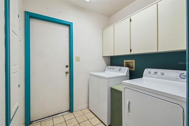 clothes washing area featuring cabinets, light tile patterned floors, and separate washer and dryer