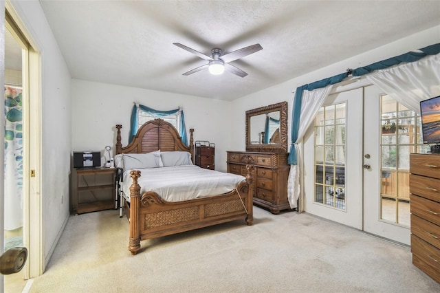 bedroom featuring ceiling fan, access to exterior, a textured ceiling, light carpet, and french doors