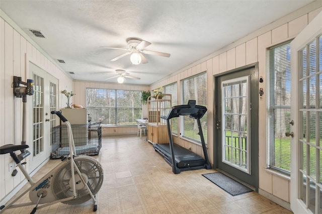 workout area with ceiling fan, ornamental molding, and a textured ceiling