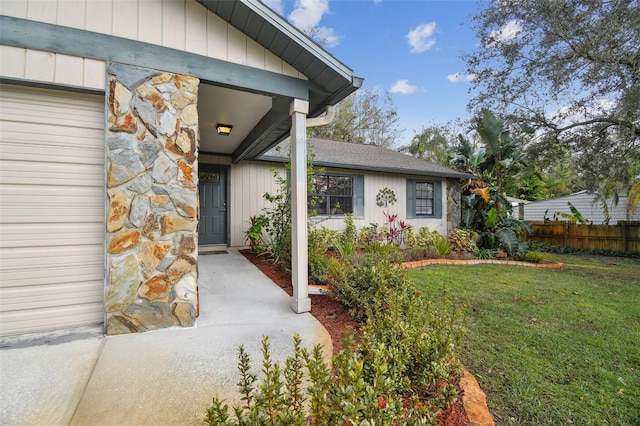 view of exterior entry featuring a yard and a garage