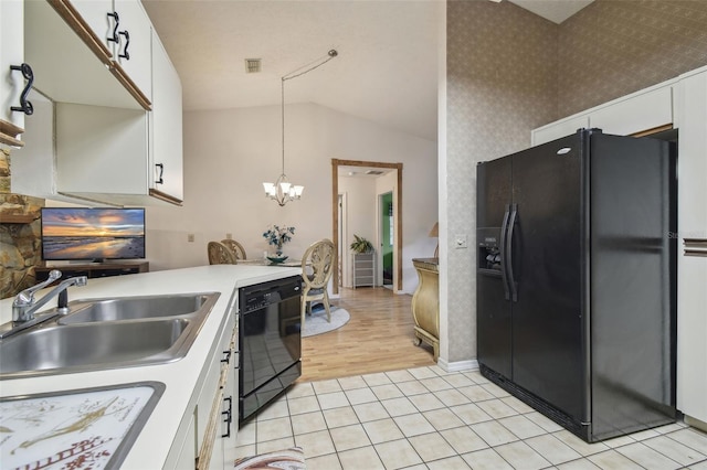 kitchen with lofted ceiling, sink, black appliances, pendant lighting, and white cabinets