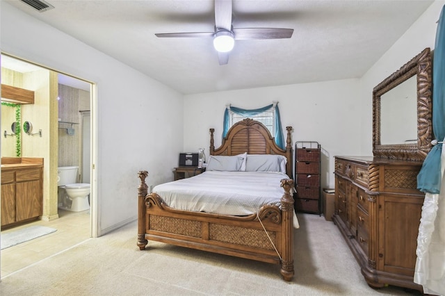 carpeted bedroom with multiple windows, ensuite bath, and ceiling fan