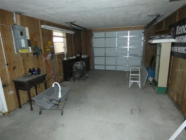 garage with electric panel and wood walls