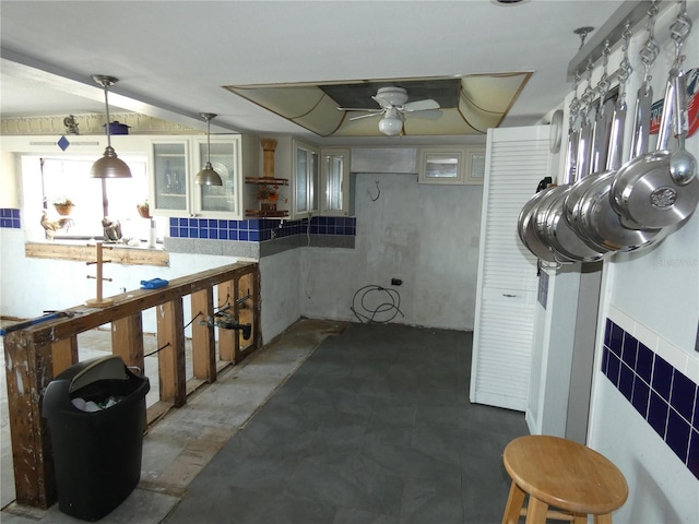 kitchen featuring hanging light fixtures, glass insert cabinets, and a ceiling fan