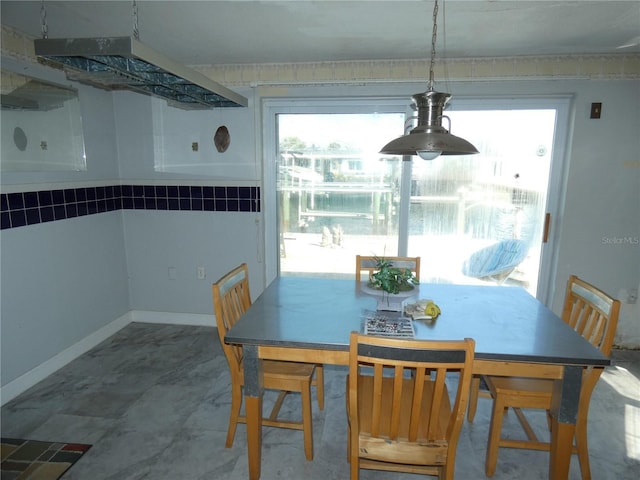 dining room featuring plenty of natural light, baseboards, and marble finish floor