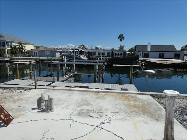 view of dock with a residential view, a water view, and boat lift