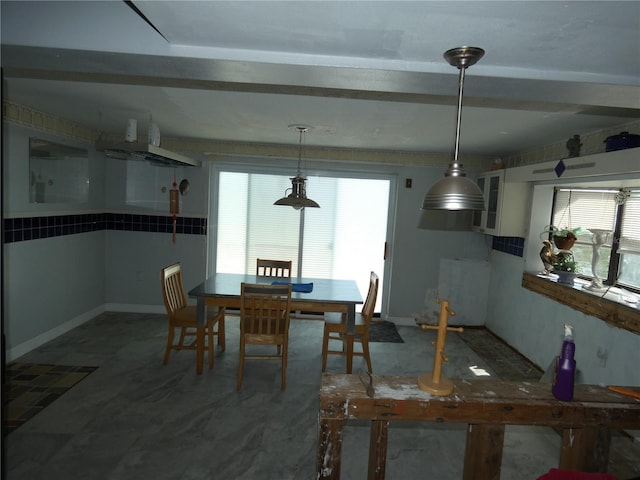 dining room with beam ceiling and baseboards