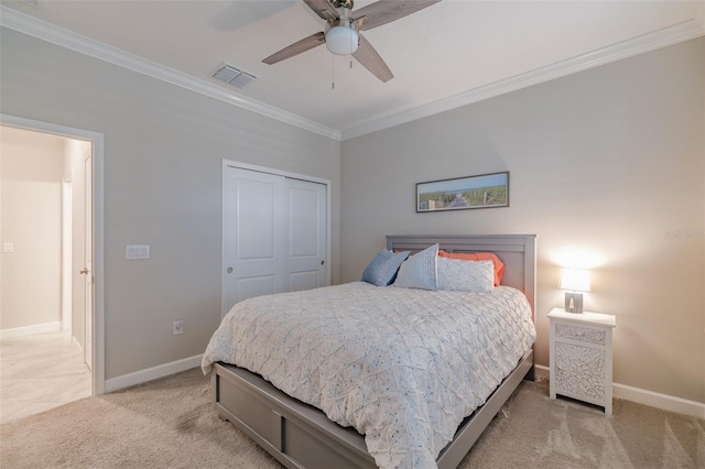 carpeted bedroom featuring ornamental molding, a closet, and ceiling fan