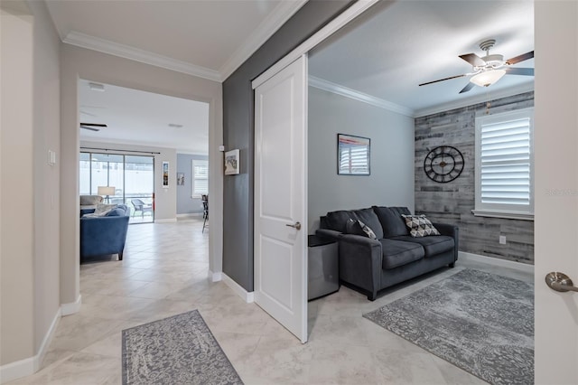 living room with crown molding, wooden walls, and ceiling fan