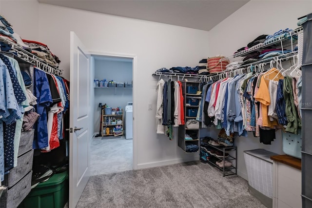 spacious closet featuring washer / clothes dryer and carpet flooring