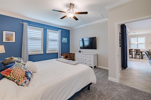 carpeted bedroom with ornamental molding and ceiling fan