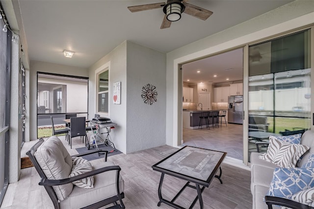 sunroom with ceiling fan and sink