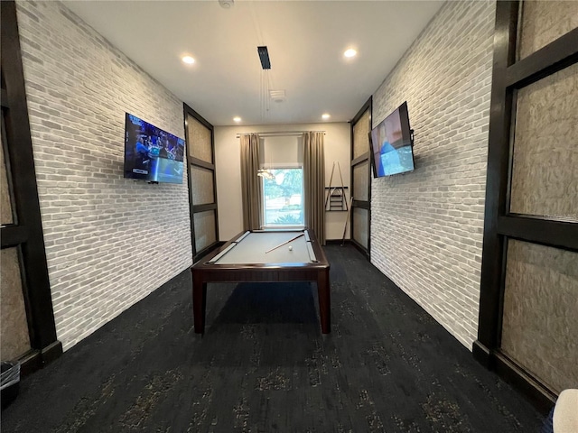 rec room with brick wall and dark hardwood / wood-style flooring