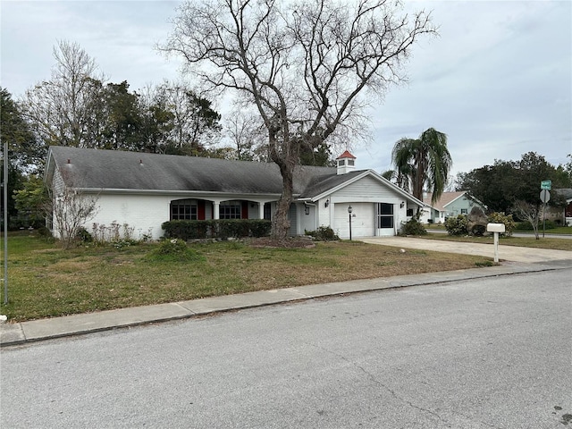 ranch-style home featuring a garage and a front lawn