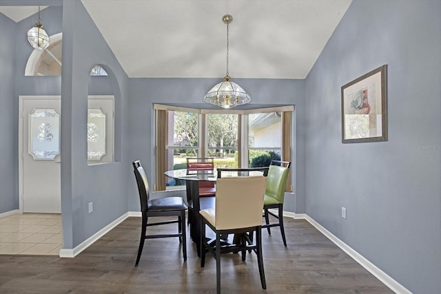 dining space featuring lofted ceiling and dark hardwood / wood-style flooring