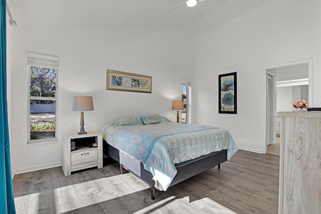 bedroom with ceiling fan, vaulted ceiling, and wood-type flooring