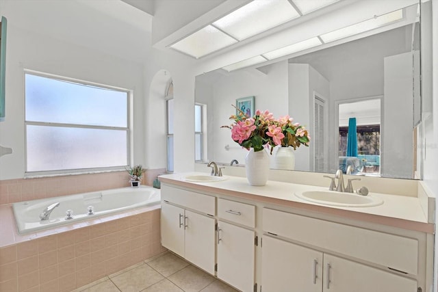 bathroom with vanity, tiled tub, and tile patterned floors