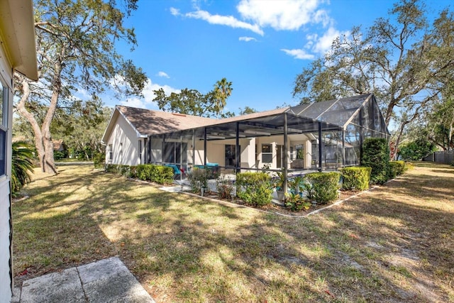 rear view of house featuring a yard and a lanai