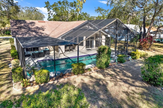 back of property featuring a patio area and glass enclosure