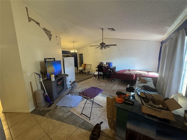 living room featuring a textured ceiling, ceiling fan, vaulted ceiling, and tile patterned floors