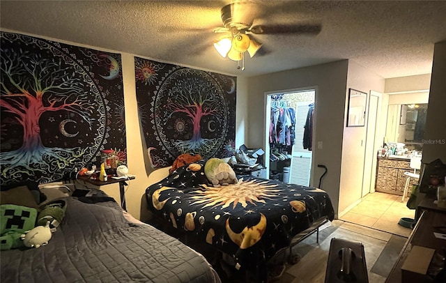 bedroom featuring a textured ceiling, ceiling fan, and light tile patterned flooring