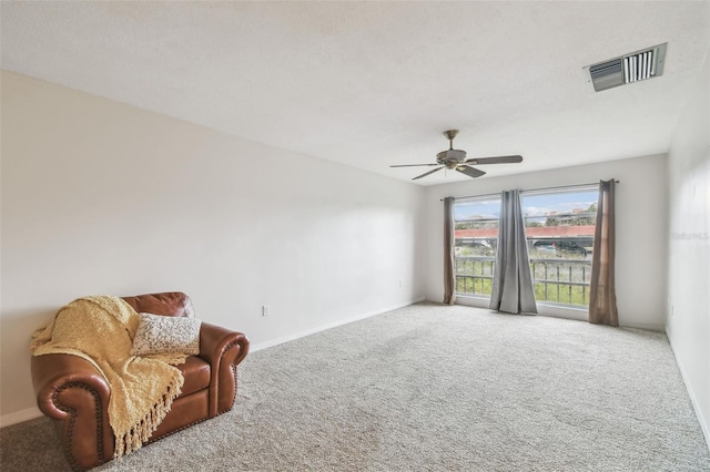 sitting room featuring ceiling fan and carpet flooring