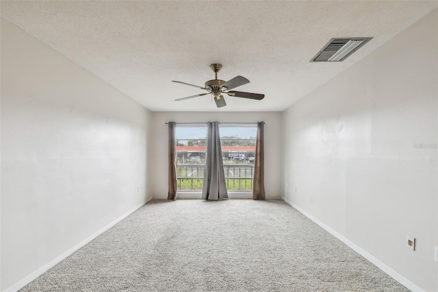 spare room with ceiling fan, a textured ceiling, and carpet